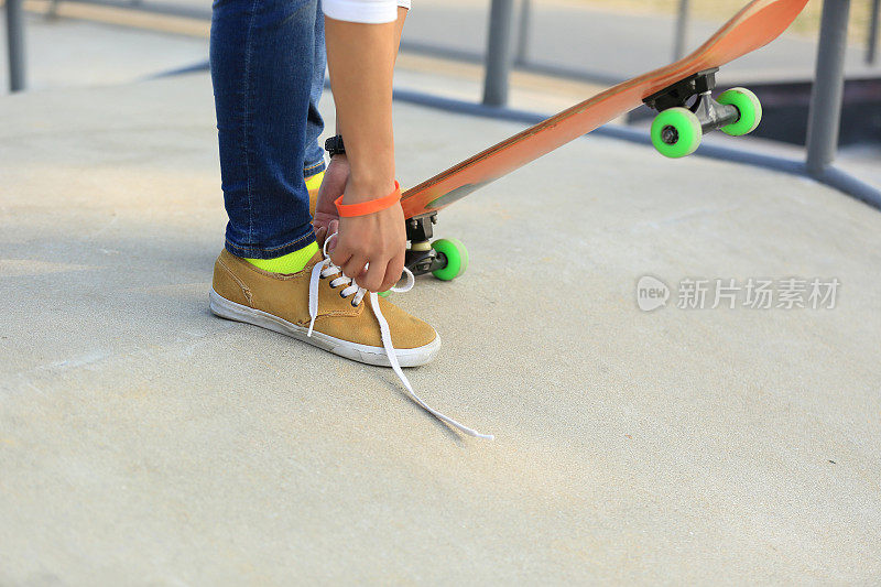 滑板手在滑板公园系鞋带