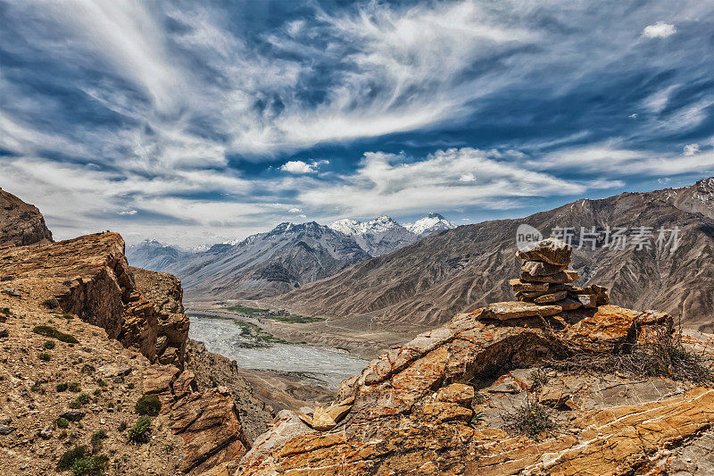 悬崖上的石堆俯瞰喜马拉雅山谷
