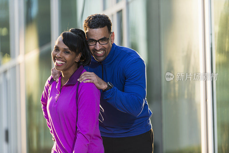 成熟的黑人夫妇穿着运动服，一起微笑