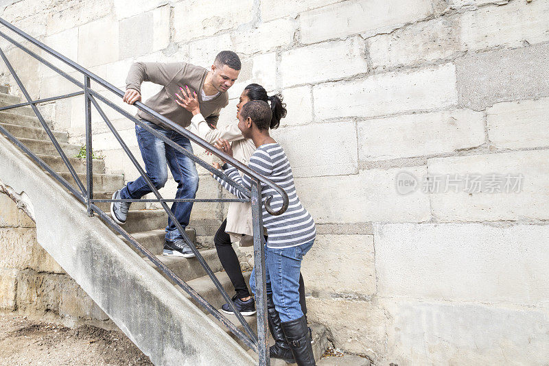 一群多民族的年轻人在楼梯上跌跌撞撞