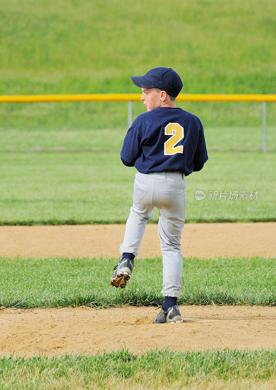 年轻男运动员在棒球场投球
