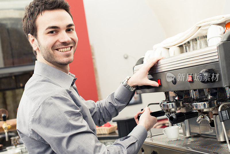 年轻的意大利咖啡师操作浓缩咖啡机