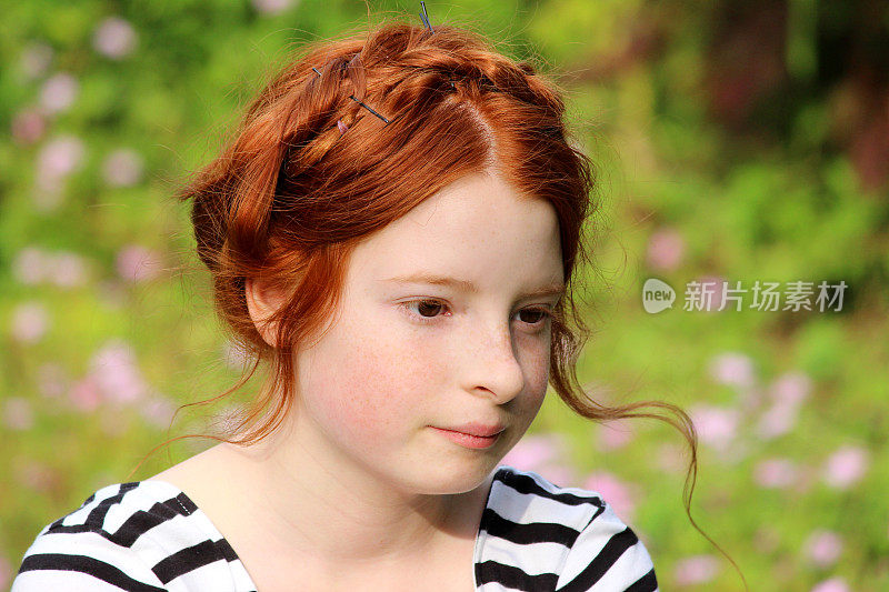 在花园里的女孩的形象，微笑着与挤奶女工的辫子发型