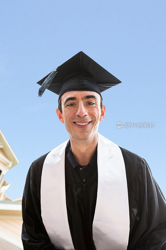 年长的男子戴着学士帽和学士服毕业
