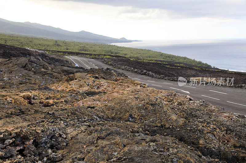 公路穿过熔岩流到海边。留尼汪岛