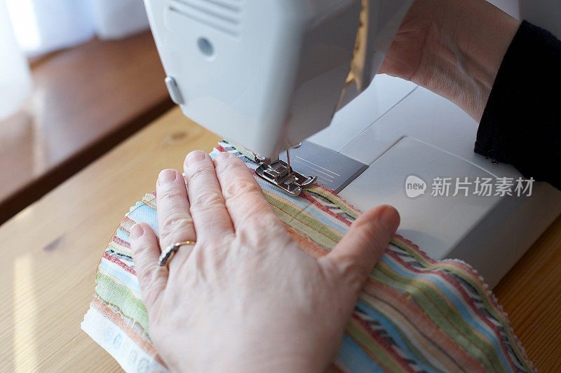 女人的手在缝纫机上