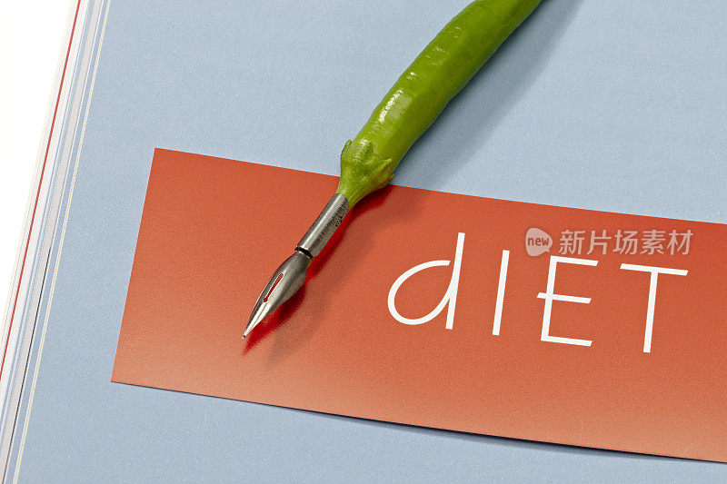 辣椒笔躺在纸上写着“节食”这个词