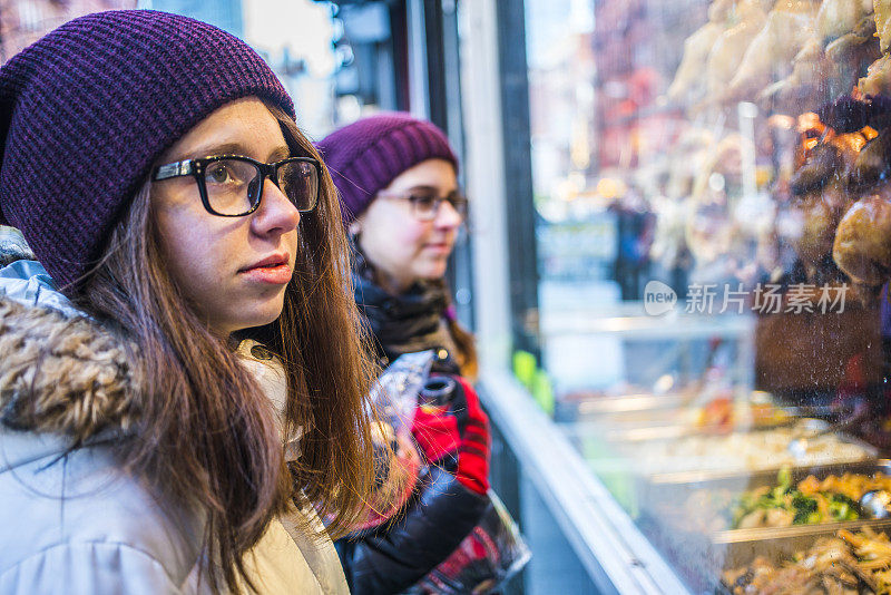 曼哈顿唐人街，女孩们在橱窗里看中国菜