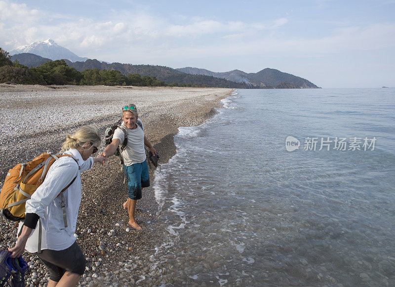 在卵石滩上，男人向女人伸出了援助之手