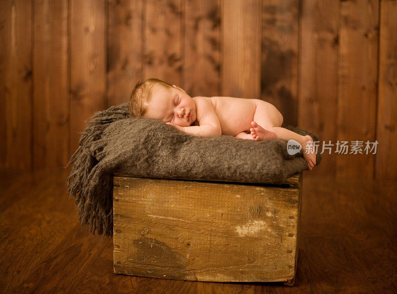 新生儿睡在木箱上