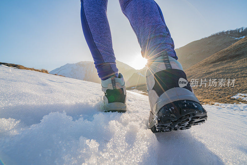 低角度的年轻女子徒步在雪山小径