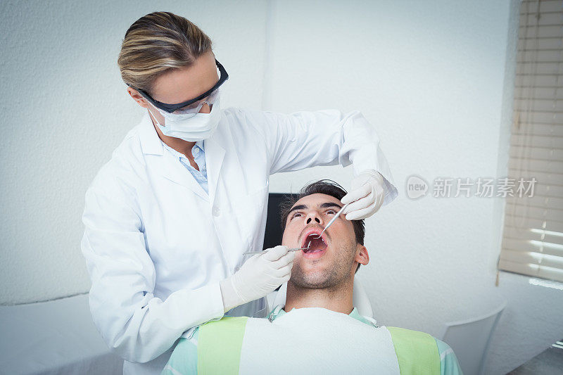 女牙医正在检查男子的牙齿