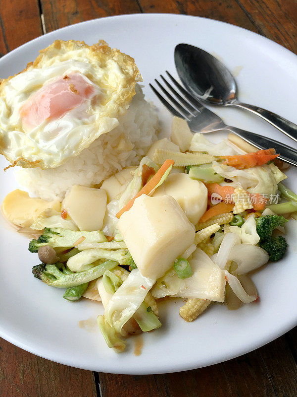 素菜蚝油炒饭和煎蛋放在白盘子里。泰国菜。
