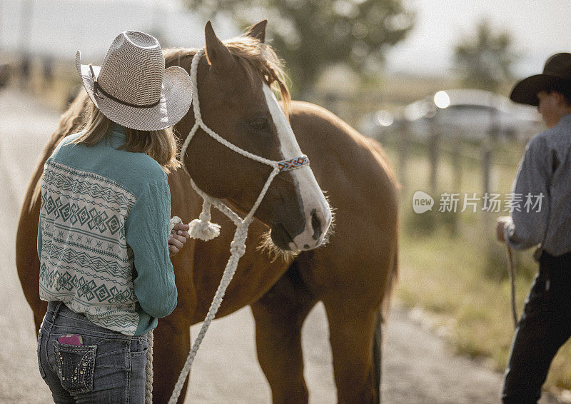 在一个牧场上，两个十几岁的男孩和女孩正准备去骑马。