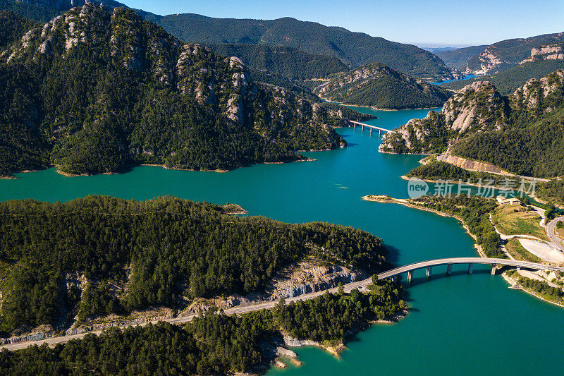 鸟瞰图美丽的绿松石湖在山上和几座桥横跨它。