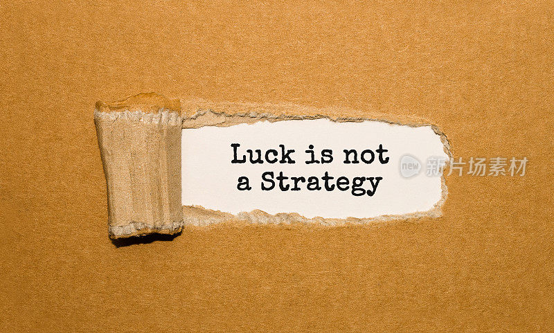 在撕破的牛皮纸后面出现的文字“运气不是策略”