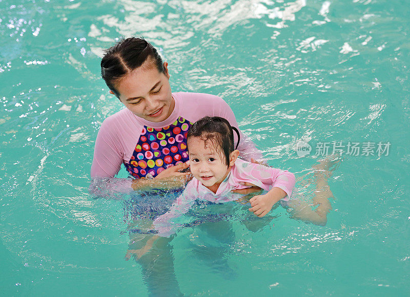 肖像快乐的小女孩在游泳池。