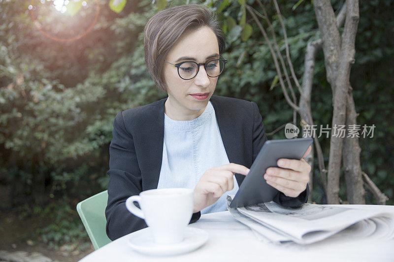 商务女性坐在咖啡馆里用着平板电脑