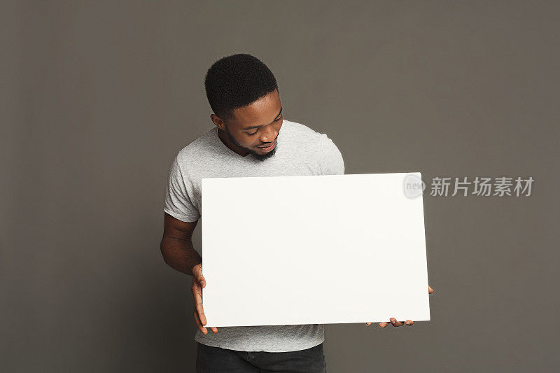 一张年轻的非洲裔美国人拿着白板的照片