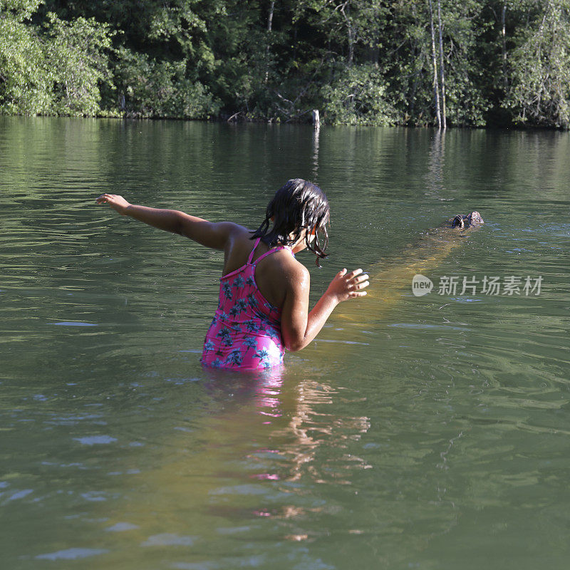 女孩走进淡水湖，在一根圆木上保持平衡