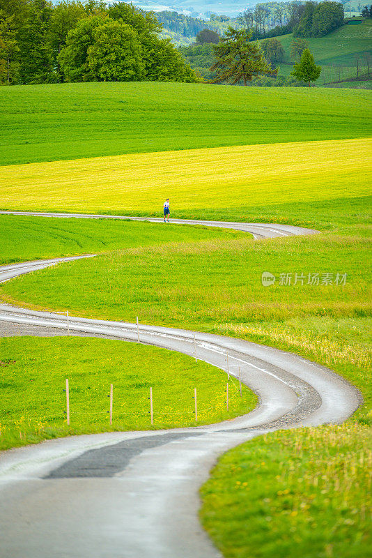 瑞士的乡村风景，男人在路上奔跑