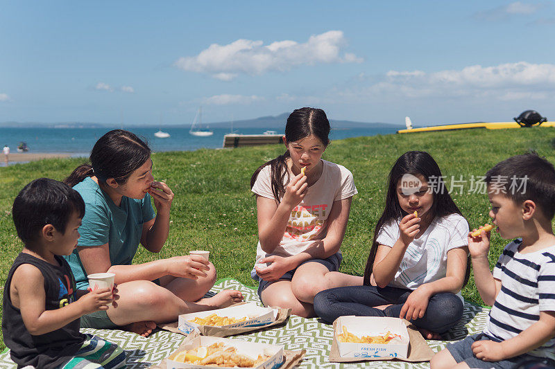 孩子们在海滩上吃鱼和薯条