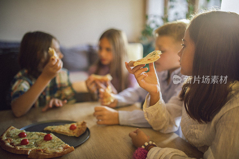 孩子们吃披萨时玩得很开心