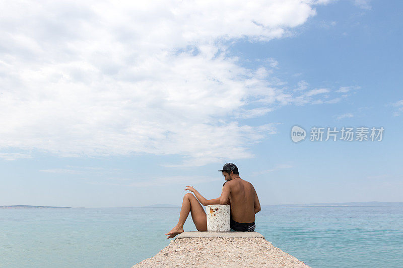 一个女人躺在男人的大腿上，靠在海边