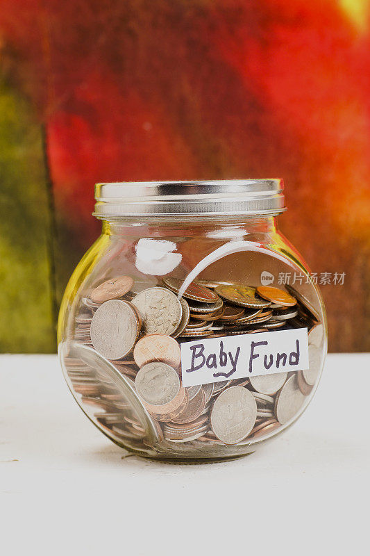 装满硬币的罐子上的婴儿基金标签
