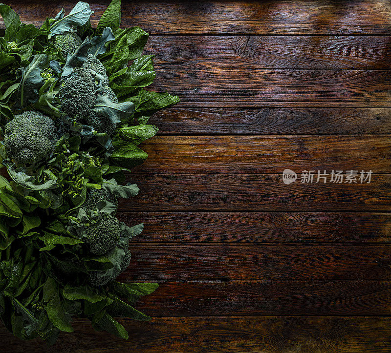 新鲜的有机，花园种植，绿叶绿色健康蔬菜在一个老柚木木托盘上老柚木镶板桌子的背景，阴影大气的乡村情绪，与良好的复制空间在右边的形象。