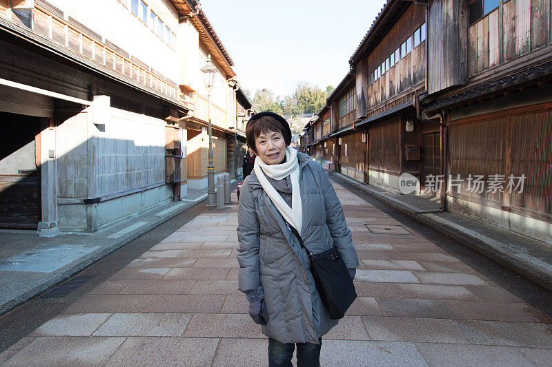 一位老年妇女在日本的老城区散步