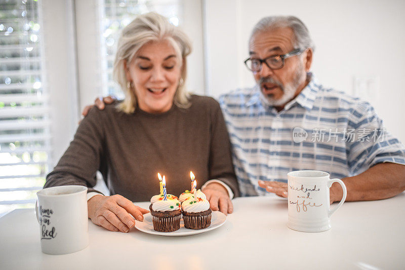 一对老年夫妇用纸杯蛋糕庆祝生日