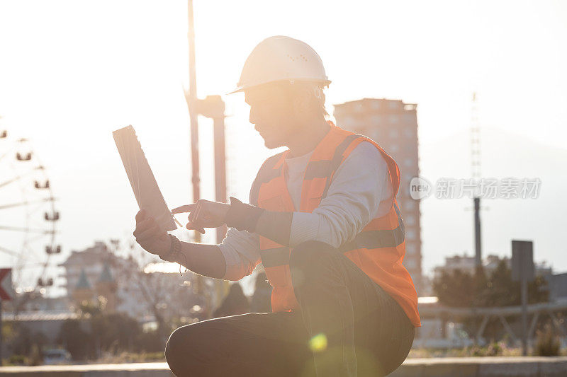 建筑工程师在建筑场地控制数据表和戴安全帽