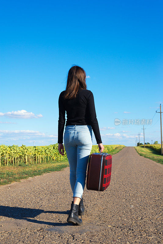 年轻女子在空旷的路上搭便车