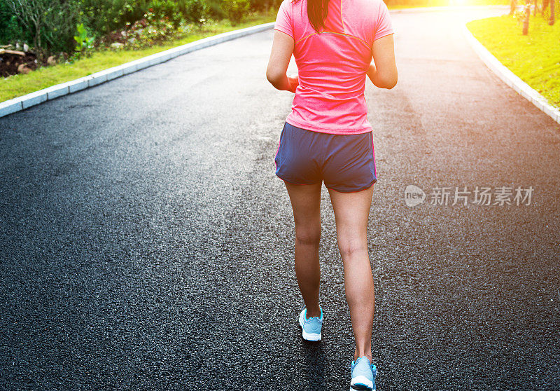 年轻的亚洲女人在公园慢跑