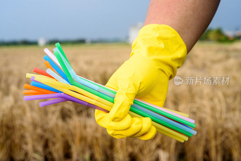 手持塑料吸管手套的手的特写——生态产业理念