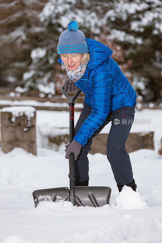 老妇人拿着雪铲