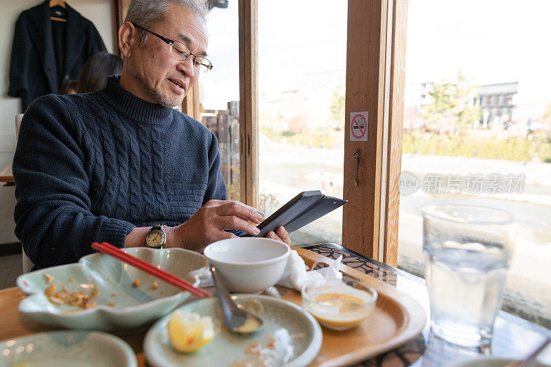 日本男子饭后使用智能手机