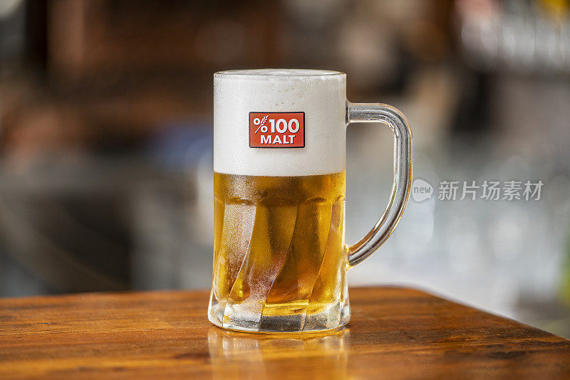 酒吧木桌上的啤酒杯。百分百麦芽啤酒。