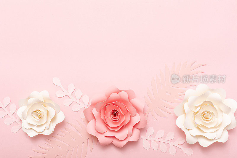 粉红色背景的鲜花贺卡。纸花平铺，俯视图