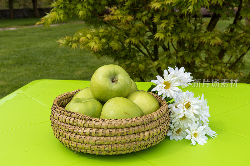 柳条篮子里的新鲜绿苹果