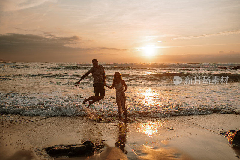 一对年轻夫妇在海滩上嬉戏