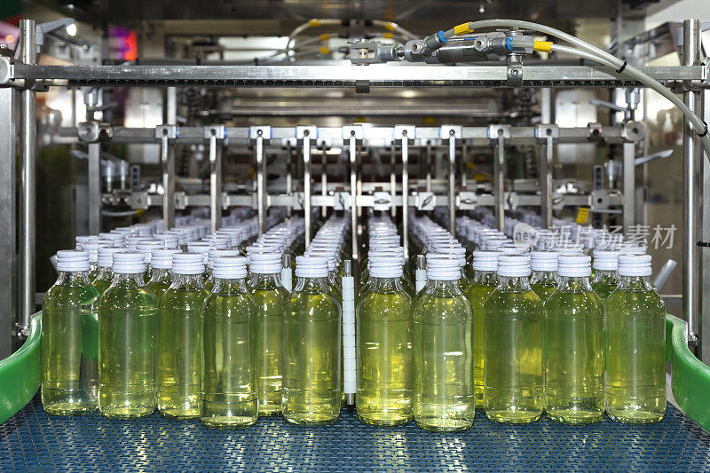 能量饮料瓶在生产线的传送带上为饮料制造的贴标和包装机做好准备。食品饮料工厂和行业概念。