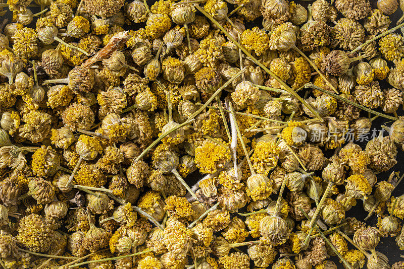 洋甘菊干花茶在黑暗的木材背景