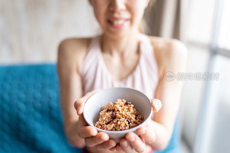 亚洲妇女拿着一碗发酵的发芽糙米