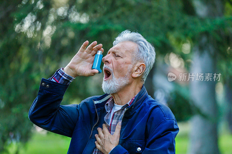 一位有呼吸问题的老人正在户外使用哮喘吸入器。