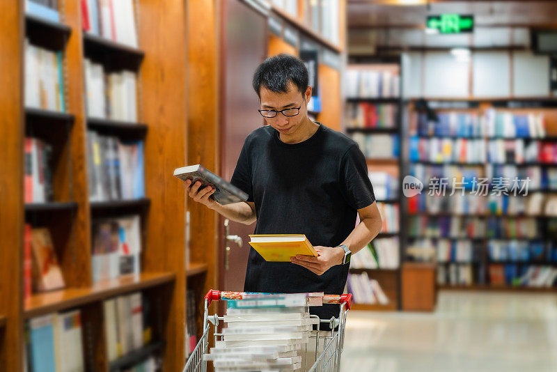 一个亚洲人推着手推车把书分类