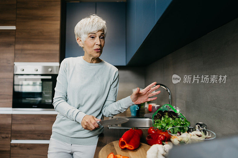 一位女士在厨房里用笔记本电脑打电话