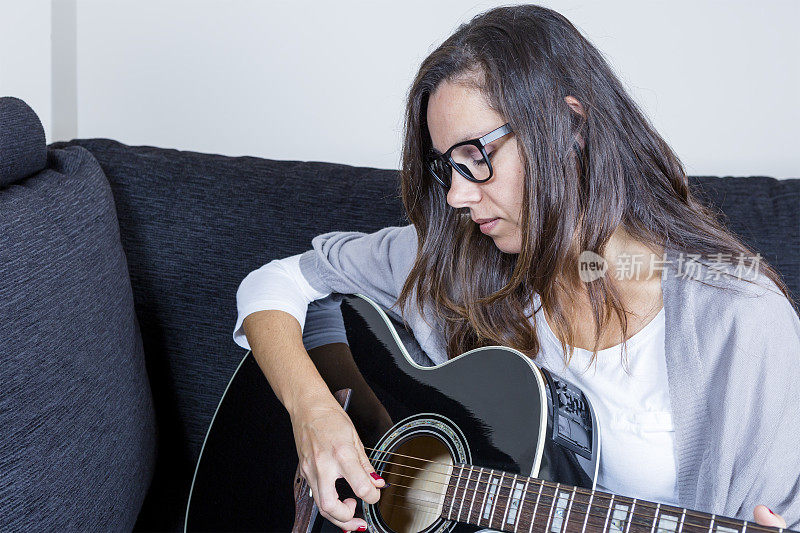 年轻女子在弹原声吉他