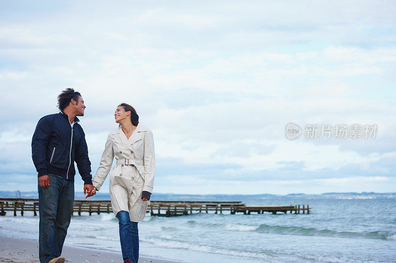 一对年轻夫妇在海边散步